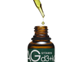 An amber glass dropper bottle with a green label reading 'AG VITAMIN d3+k2' on a white background, with a glass dropper above dispensing a drop of golden oil.