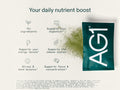 A single AG1 supplement packet shown on a light beige background with marketing text reading 'Your daily nutrient boost' and feature icons for ingredients, digestion, energy, immunity, stress balance, focus, and concentration.