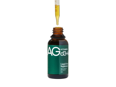 An amber glass dropper bottle labeled AGd3+ Vitamin D3+ Liquid Food Supplement, with a glass dropper above the open bottle on a white background.