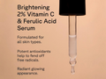 Vitamin C and Ferulic Acid Serum dropper with text on a beige background