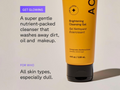 Orange cleansing gel tube with text on a beige background