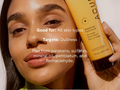 Woman holding a skincare product with text about its benefits and ingredients.