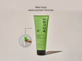 Acure shampoo bottle with a smaller inset image of a hand holding a bottle, on a beige background.