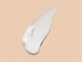 White cream or lotion swatch on a beige background