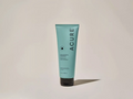 Acure lotion tube on a beige background
