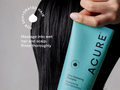 Person holding a bottle of Acure Ultra Hydrating Shampoo with text on dehydrated hair.