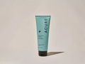 Acure shampoo tube on a beige background