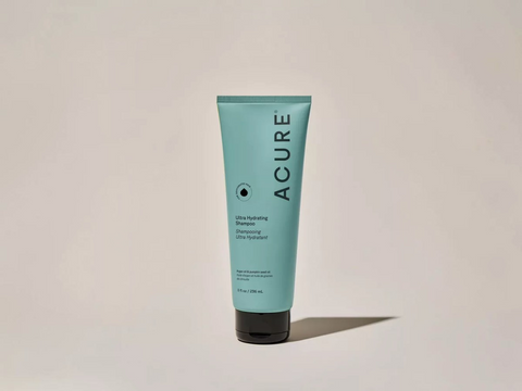 Acure shampoo tube on a beige background