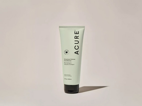 Acure hair product tube on a light beige background