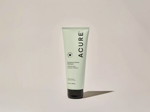 Acure shampoo tube on a beige background