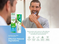 Man brushing his teeth with Aloe Dent toothpaste packaging displayed.