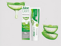 Aloe Dent Whitening toothpaste packaging with aloe vera slices on a light gray background