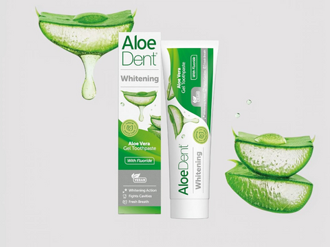 Aloe Dent Whitening toothpaste packaging with aloe vera slices on a light gray background