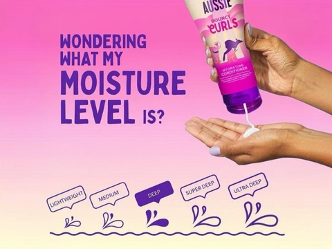 Aussie product being applied to hands with text about moisture levels on a pink background