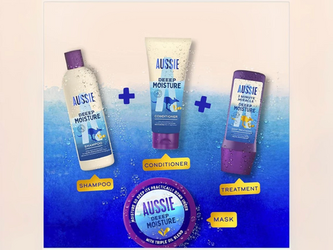 Aussie shampoo, conditioner, and treatment bottles on a blue and beige gradient background