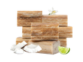 Stack of Australian Botanical Soap coconut bars with coconut pieces and a lime wedge on a white background