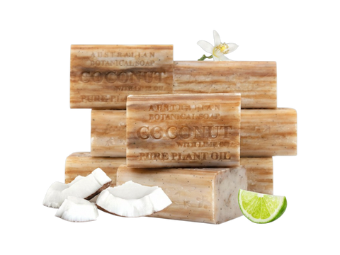 Stack of Australian Botanical Soap coconut bars with coconut pieces and a lime wedge on a white background