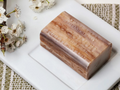 Bar of soap with 'Botanic' branding on a white surface with flowers.