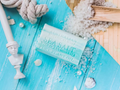 Bar of soap with ocean salt and minerals on a blue wooden surface with decorative items.