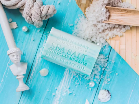 Bar of soap with ocean salt and minerals on a blue wooden surface with decorative items.