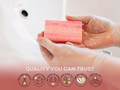 Person holding a bar of soap with 'Goats Milk' branding, against a blurred background.
