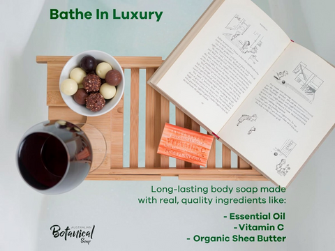 Bathe In Luxury soap bar with a book, bowl of fruit, and glass on a wooden tray.