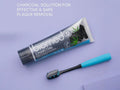 BIOMED Black Charcoal Toothbrush & toothpaste, medium bristles, on a clean background.
