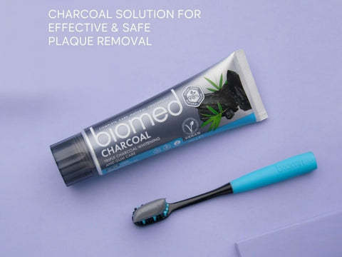 BIOMED Black Charcoal Toothbrush & toothpaste, medium bristles, on a clean background.