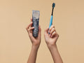 BIOMED Black Charcoal Toothbrush & calcimax toothpaste, medium bristles, on a clean background.