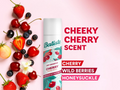 Batiste dry shampoo bottle with cherry and berry ingredients on a pink background