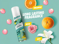 Baliste hair product with orange, rose, and lily flowers on a teal background