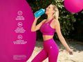 Woman in pink athletic wear holding a blue supplement bottle with a pink background and nutritional information.