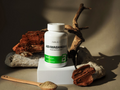 Supplement bottle labeled 'ASHWAGANDHA' on a neutral background with natural elements.
