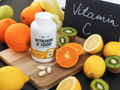 Supplement bottle labeled 'Vitamin C 1000' on a cutting board with fruits