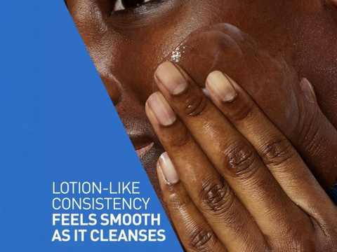 Close-up of a person's hand applying lotion to their face with a blue background and text about lotion-like consistency.