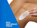 Person applying a white cream patch on their skin with a blue and white background.