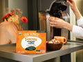 How to Use: A Four Sigmatic coffee pod next to a Keurig brewer.