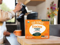 How to Use: A Four Sigmatic coffee pod next to a Keurig brewer.