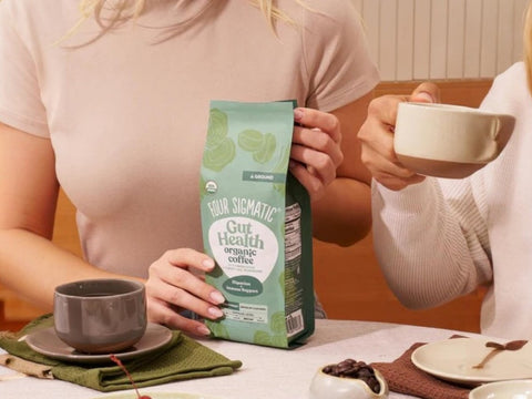 How to Use: Four Sigmatic ground coffee being scooped next to a coffee maker.