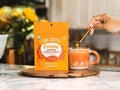 How to Use: Scoop of Four Sigmatic Mushroom Blend powder next to a glass of liquid.