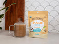 Four Sigmatic creamer to a steaming mug.