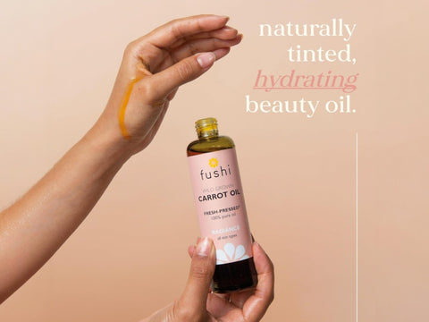 Fushi Wild Grown Carrot Oil 100 ml oil being applied to skin or hair during routine