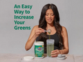 Garden of Life Perfect Food Super Greens Formula Powder scoop with green superfood powder next to tub