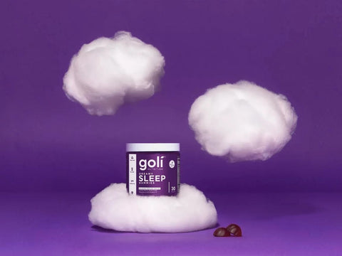Container of golfi sleep product on a purple background with cotton and berries.