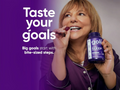 Woman in purple pajamas holding a goli sleep supplement bottle with text 'Taste your goals' on a purple background.