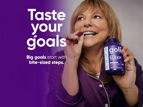 Woman in purple pajamas holding a goli sleep supplement bottle with text 'Taste your goals' on a purple background.