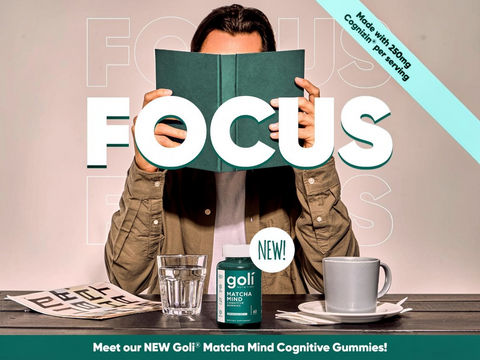 Person holding a book with 'FOCUS' on it, with a cup of coffee and matcha product in the foreground.