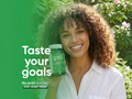 Woman holding a Goli supplement bottle with green background and text 'Taste your goals'.