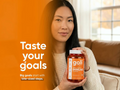 Woman holding a goli supplement bottle with an orange background and text.
