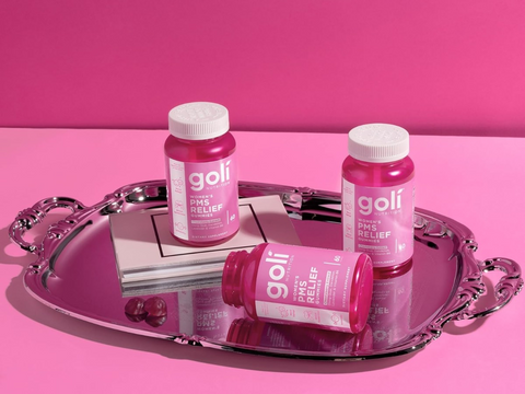 Three bottles of goli PM/AM Relief on a pink background